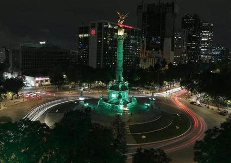 Cars drive past the Angel of Independence monument, lit up in green in Mexico City, Thursday, June 1, 2017. Mexico City's Mayor Miguel Angel Mancera announced on his Twitter account that the city would light up in green to reaffirm Mexico's support for the Paris climate agreement after U.S. President Donald Trump withdrew the U.S. from the accord. (AP Photo/Marco Ugarte)
