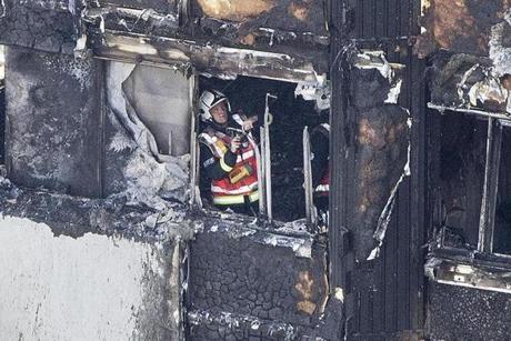 LONDON FIRE SLIDER A firefighter checks damage after a fire engulfed the 24-storey Grenfell Tower, in west London, Wednesday June 14, 2017. Fire swept through a high-rise apartment building in west London early Wednesday, killing an unknown number of people with around 50 people being taken to hospital. (Rick Findler/PA via AP)
