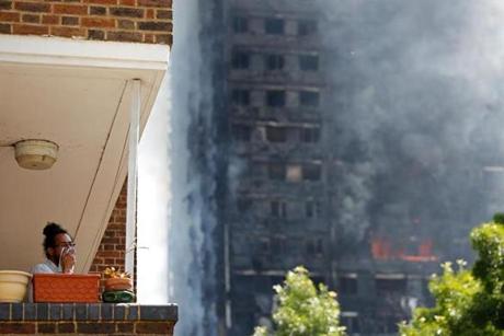 LONDON FIRE SLIDER A man covers his face with a cloth as smoke billows from Grenfell Tower, a residential block of flats on June 14, 2017 in west London, as firefighters continue to control a fire. Shaken survivors of a blaze that ravaged a west London tower block told Wednesday of seeing people trapped or jump to their doom as flames raced towards the building's upper floors and smoke filled the corridors. / AFP PHOTO / Adrian DENNISADRIAN DENNIS/AFP/Getty Images
