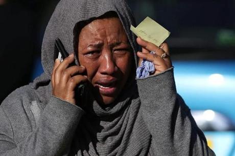 LONDON FIRE SLIDER A woman cries as she tries to locate a missing relative suspected of being affected by the massive fire that engulfed Grenfell Tower, a residential block on June 14, 2017 in west London. The massive fire ripped through the 27-storey apartment block in west London in the early hours of Wednesday, trapping residents inside as 200 firefighters battled the blaze. Police and fire services attempted to evacuate the concrete block and said 