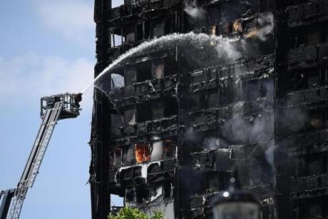 LONDON FIRE SLIDER LONDON, ENGLAND - JUNE 14: Fire fighters drench the burning 24 storey residential Grenfell Tower block in Latimer Road, West London on June 14, 2017 in London, England. The Mayor of London, Sadiq Khan, has declared the fire a major incident as more than 200 firefighters are still tackling the blaze while at least 50 people are receiving hospital treatment. (Photo by Carl Court/Getty Images)

