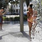 Aaiyahana Stewart (right), 5, of Cambridge and Jonathan Ferro, 6, of Cambridge cooled off under the fountain at Gore Park in Cambridge. 