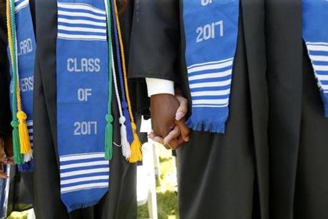In this Saturday, May 13, 2017 photo, graduates hold hands during a commencement ceremony at Dillard University in New Orleans. With an enrollment of 1,200, Dillard ranks second in the country in black physics undergrads. (AP Photo/Gerald Herbert)
