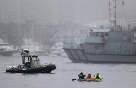 People in kayaks made their way out into the foggy Boston Harbor Saturday.
