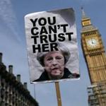 A protester carried a placard critical of Prime Minister Theresa May during demonstrations near Big Ben Wednesday.
