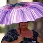 A Phoenix resident used an umbrella to get relief from the triple-digit temperatures.