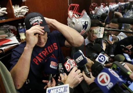 New England Patriots tight end Rob Gronkowski puts on a cap signifying the Patriots clinching of the AFC Division after their 41-13 win over the Miami Dolphins in an NFL football game Sunday, Dec. 14, 2014, in Foxborough, Mass. (AP Photo/Charles Krupa)

