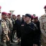 A handout picture released by the Iraqi prime minister's press office on July 9, 2017, shows Iraqi Prime Minister Haider al-Abadi (C) greeting army officers upon his arrival in Mosul. Abadi declared victory in the 