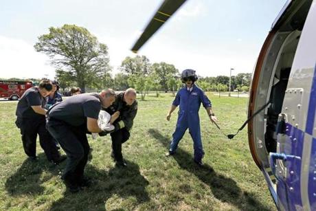 A man who fell from a ladder was carried to a Boston MedFlight helicopter by Norfolk firefighters and EMTs under the guidance of Scott McKinnon (right).
