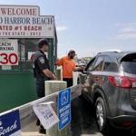 Gloucester, MA: 07-1-2017: Gloucester police officer Al D'Angelo (left) and parking attendant Jack Doyle man the booth at the entrance to the parking lot at Good Harbor Beach in Gloucester, Mass. July 1, 2017. When the photo was taken just after 11am, the lot was still open to non-resident visitors paying to park. Photo/John Blanding, Boston Globe staff story/Hattie Bernstein, NOWK ( 16zobeaches )