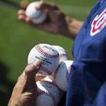 Boston Red Sox bullpen catcher Manni Martinez hands out balls to players during a spring training baseball workout in Fort Myers, Fla., Sunday, Feb. 19, 2017. (AP Photo/David Goldman)