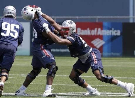 New England Patriots defensive end Derek Rivers, left, defensive tackle Adam Butler, center, and defensive end Deatrich Wise, right, perform field drills during NFL football practice, Tuesday, June 13, 2017, in Foxborough, Mass. (AP Photo/
