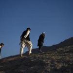 Afghan men walk on a hilltop on the outskirts of Kabul.