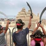In front of a centerpiece display showing the USS Constitution, young pirates raised their swords at the Revere Beach International Sand Sculpting Festival in Revere on Saturday.