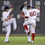 Boston Red Sox left fielder Andrew Benintendi, left, right fielder Mookie Betts (50) and center fielder Jackie Bradley Jr. celebrate after defeating the Toronto Blue Jays in a baseball game at Fenway Park in Boston, Wednesday, July 19, 2017. The Red Sox won 5-1. (AP Photo/Charles Krupa)