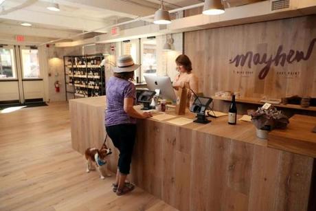 South Boston MA 07/22/17 Chadler Parker (cq) selling a bottle of wine to Joann Dunlavey (cq) and her dog, Bentley at Mayhew a retail wine shop in the Fort Point neighborhood is located across the street from the New Amazon Headquarters. (Matthew J. Lee/Globe staff) topic: reporter: 
