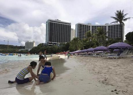 A family plays in the sand in Tumon, Guam. 
