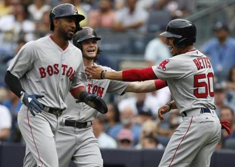 NEW YORK, NY - AUGUST 12: Andrew Benintendi #16 of the Boston Red Sox is congratulated by teammates Eduardo Nunez #36 and Mookie Betts #50 after all three scored on Benintendi's three- home run against the New York Yankees during the third inning of a game at Yankee Stadium on August 12, 2017 in the Bronx borough of New York City. (Photo by Rich Schultz/Getty Images)
