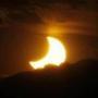 In this file photo, the solar eclipse is seen as the sun sets behind the Rocky Mountains from downtown Denver in May 2012.