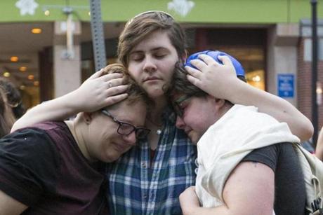 From left to right, Sasha Kaufman, Roni Simcha Miller and August Eberlein, embrace after a vigil at the Holocaust Memorial.

