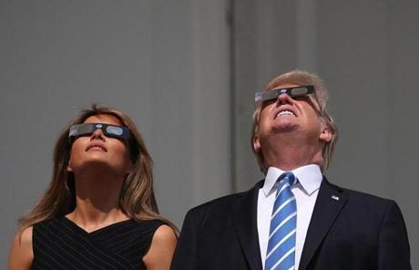 ECLIPSE SLIDER6 WASHINGTON, DC - AUGUST 21: US President Donald Trump and his wife first lady Melania Trump wear special glasses to view the solar eclipse at the White House on August 21, 2017 in Washington, DC. Millions of people have flocked to areas of the U.S. that are in the 