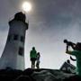 People gathered on the breakwater around the Old Scituate Lighthouse to look at the solar eclipse on Monday. 