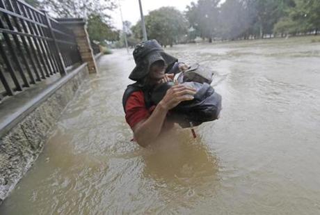 Residents wade through floodwaters from Tropical Storm Harvey Sunday, Aug. 27, 2017, in Houston, Texas. (AP Photo/David J. Phillip)
