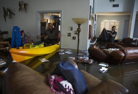 A father and son looked for important papers and heirlooms inside their house after it was flooded by heavy rains from Hurricane Harvey.
