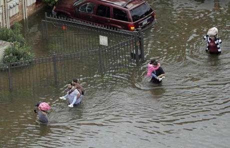 Residents wade through floodwaters as they evacuate their homes near the Addicks Reservoir as floodwaters from Tropical Storm Harvey rise Tuesday, Aug. 29, 2017, in Houston. (AP Photo/David J. Phillip)

