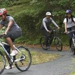 Then-President Barack Obama (center), daughter Malia (right), and Michelle Obama riding bikes in West Tisbury in 2015.