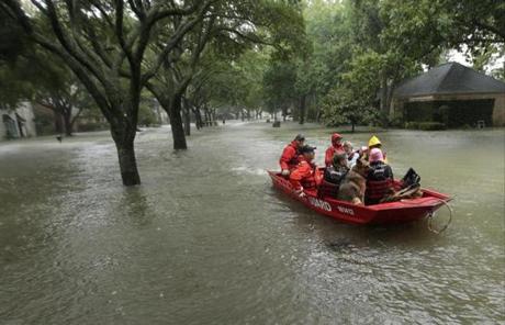 A Coast Guard rescue team evacuates people from a neighborhood inundated by floodwaters from Tropical Storm Harvey on Monday, Aug. 28, 2017, in Houston, Texas. (AP Photo/Charlie Riedel)
