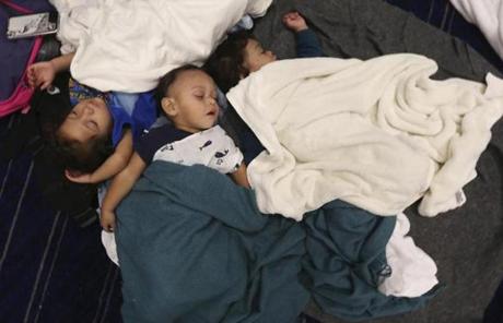 Robert Salgado, center, sleep with relatives Jesse Alexander Leija, right, and Leliana Salgado on the floor at the George R. Brown Convention Center that has been set up as a shelter for evacuees escaping the floodwaters from Tropical Storm Harvey in Houston, Texas, Tuesday, Aug. 29, 2017. (AP Photo/LM Otero)
