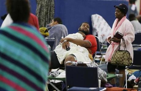 People rest at the George R. Brown Convention Center that has been set up as a shelter for evacuees escaping the floodwaters from Tropical Storm Harvey in Houston, Tuesday, Aug. 29, 2017. (AP Photo/LM Otero)
