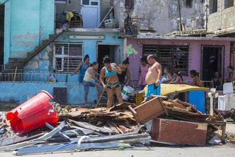 People clear debris outside their homes after the passing of Hurricane Irma in Havana, Cuba, Monday, Sept. 11, 2017. Cuban state media reported 10 deaths despite the country's usually rigorous disaster preparations. More than 1 million were evacuated from flood-prone areas. (AP Photo/Desmond Boylan)

