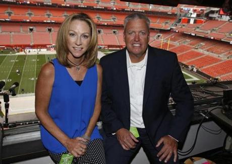 ESPN broadcasters Beth Mowins, left, and Rex Ryan pose in the booth before an NFL football game between the New York Giants and the Cleveland Browns, Monday, Aug. 21, 2017, in Cleveland. (AP Photo/Ron Schwane)
