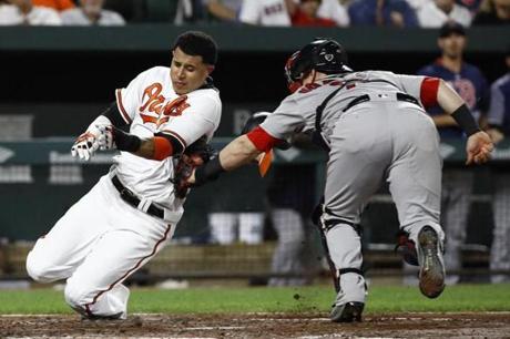 Baltimore Orioles' Manny Machado, left, is tagged out by Boston Red Sox catcher Christian Vazquez as he tries to score on Jonathan Schoop's single in the third inning of a baseball game in Baltimore, Tuesday, Sept. 19, 2017. (AP Photo/Patrick Semansky)
