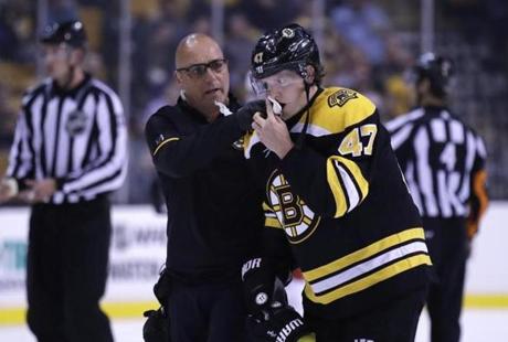 Boston Bruins defenseman Torey Krug (47) is helped off the ice during the second period of a preseason NHL hockey game in Boston, Tuesday, Sept. 19, 2017. (AP Photo/Charles Krupa)
