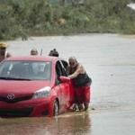 Residents pushed a car in a flooded road after the passing of Hurricane Maria, in Toa Baja, Puerto Rico, Friday.
