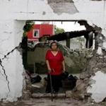 In this Saturday, Sept. 23, 2017 photo, Margarita De La Cruz stands inside her home that was declared condemned after it was damaged by an earthquake in Atzala, Mexico. 