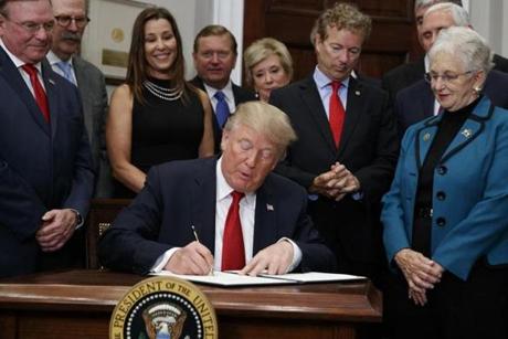 FILE - In this Thursday, Oct. 12, 2017, file photo, Dave Ratner, second from left, and others watch as President Donald Trump signs an executive order on health care in the Roosevelt Room of the White House in Washington. Ratner, owner of Dave's Soda and Pet City in Massachusetts, is under fire after he was photographed last week with Trump. Ratner said he's 