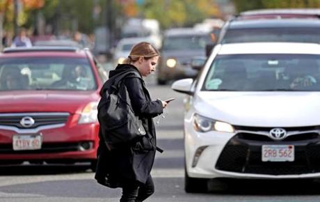 BOSTON, MA - 11/02/2017: A person crossing Commonwealth Avenue is oblivious to traffic or other people. People walking and texting, emailing or Instagramming around Boston (David L Ryan/Globe Staff ) SECTION: LIFESTYLE TOPIC 03textwalk
