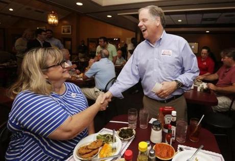Democratic Senate nominee Doug Jones, right, shakes hands with Toni Vaughn, left, of Chelsea, Ala., as Jones campaigns at Niki's West restaurant, Wednesday, Sept. 27, 2017, in Birmingham, Ala. Jones will face former Alabama Chief Justice and U.S. Senate candidate Roy Moore. (AP Photo/Brynn Anderson)
