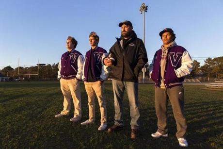 Martha?s Vinyeard Regional High School football coach, Ryan Kent (3rd from left) is photographed with players, Sam Rollins, 18, Cooper Bennett, 17, and Zachary Moreis, 17, all of Edgartown, MA, on the football field after their season was cancelled prematurely due to not having enough uninjured players. ?We?re all mourning the loss of a season that ended too soon,? says coach Kent. ( Julia Cumes for The Boston Globe )
