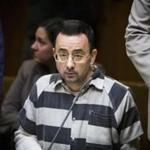 This photo taken May 12, 2017, shows Dr. Larry Nassar listening during a preliminary hearing in Mason, Mich. A person with knowledge of the agreement says the former Michigan State University and USA Gymnastics doctor will plead guilty to multiple charges of sexual assault and face at least 25 years in prison. The person was not authorized to publicly discuss the agreement ahead of a Wednesday court hearing and spoke to The Associated Press on condition of anonymity. Nassar is charged with molesting seven girls under the guise of treatment at his home and a campus clinic. All but one were gymnasts. The plea deal calls for a minimum prison sentence of 25 years. But the judge could go higher and set the minimum at 40 years. (Matthew Dae Smith/Lansing State Journal via AP)