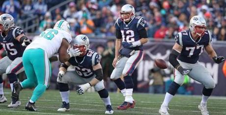 Foxborough, MA: 11-26-17: The Dolphins scored their first touchdown of the game in the second quarter when a mixup between Patriots center Ted Karras (75,far left) and quarterback Tom Brady (12) had Karras snapping the ball before Brady was expecting it. Miami's Reshad Jones (not pictured) recovered the fumble and returned it 14 yards to the end zone for the score. The New England Patriots hosted the Miami Dolphins in a regular season NFL football game at Gillette Stadium. (Jim Davis/Globe Staff)
