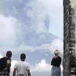 Tourists watched the Mount Agung volcano erupting as they visited a temple in Karangasem, Indonesia, Monday.