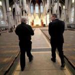 Father Kevin O'Leary (left) and John Fish of Suffolk Construction walked through the Cathedral of the Holy Cross in Boston.