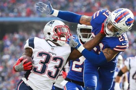 ORCHARD PARK, NY - DECEMBER 3: Dion Lewis #33 of the New England Patriots stiff arms Jordan Poyer #21 of the Buffalo Bills during the second quarter on December 3, 2017 at New Era Field in Orchard Park, New York. (Photo by Tom Szczerbowski/Getty Images)
