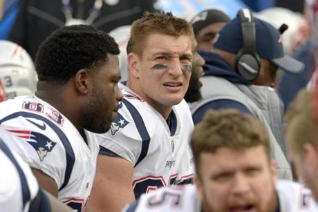 New England Patriots tight end Rob Gronkowski, center, looks on from the bench during the first half of an NFL football game against the Buffalo Bills, Sunday, Dec. 3, 2017, in Orchard Park, N.Y. (AP Photo/Adrian Kraus)
