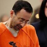 (FILES) This file photo taken on November 22, 2017 shows former Michigan State University and USA Gymnastics doctor Larry Nassar (L) as he reacts to defense attorney Shannon Smith (R) reading the charges he pled to in Ingham County Circuit Court in Lansing, Michigan. Larry Nassar is scheduled to be sentenced in federal court in Michigan on December 7, 2017 after pleading guilty to child pornography charges.He has also pleaded guilty to 10 counts of sexual assault in two other cases in Michigan, admitting that he abused young athletes under the guise of offering medical treatment. / AFP PHOTO / JEFF KOWALSKYJEFF KOWALSKY/AFP/Getty Images